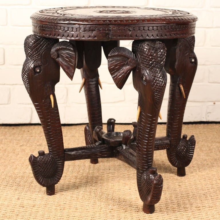 Heavily carved solid rosewood side table or teapoy with stylized elephant legs with bone and ivory inlay.