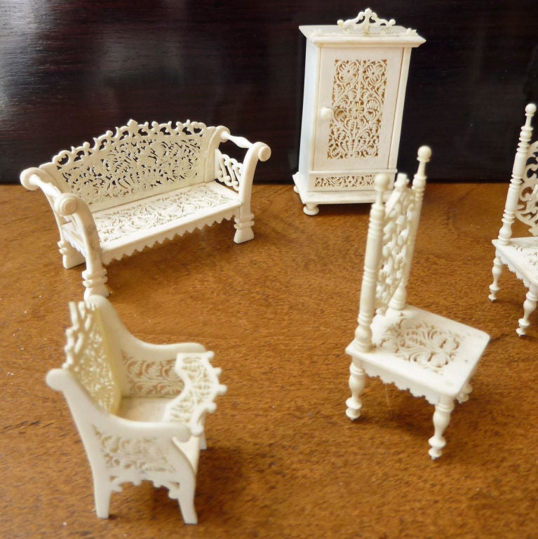 Intricately carved set of nine bone or ivory miniature furniture. Small cabinet opens to reveal glassware on shelves with mirror back.