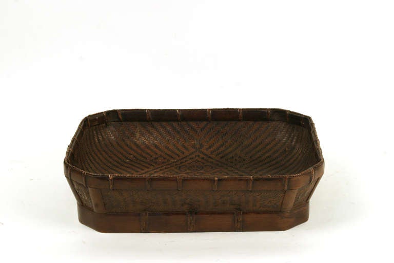 This Zhejiang bamboo flat basket is from the Zhejiang province in China. It is hand woven out of rattan with a bamboo frame.
