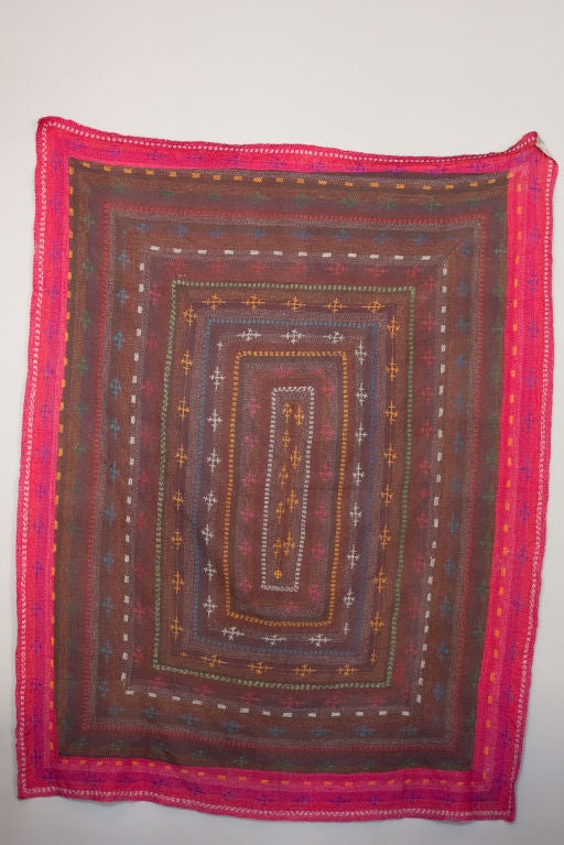 Handstitched cotton quilt with vibrant multi-color thread and a darker background with hot pink edges.