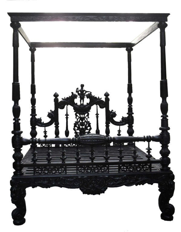 A recent acquistion from a Palace in India, this Mahogany Four Poster bed is of exceptional quality. It has a set of four figures on the feet with scroll ends. The headboard has wonderful carved details with a tall standing figure in the center