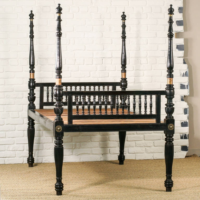 A very rare solid ebony Anglo-Indian four-poster bed. The four turned posts have fluted legs and solid brass connecting hardware. Headboard and footboard have straight top and bottom rails intersected by ebony spindles. The mattress sits directly on