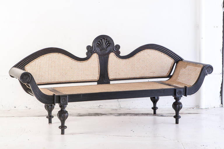 Dutch colonial settee in solid ebony. Elaborate carving in all major ebony surfaces with scallop designs (typical of this period and style) on the back and ends of arm rests. All newly caned.

Seat height= 16.5