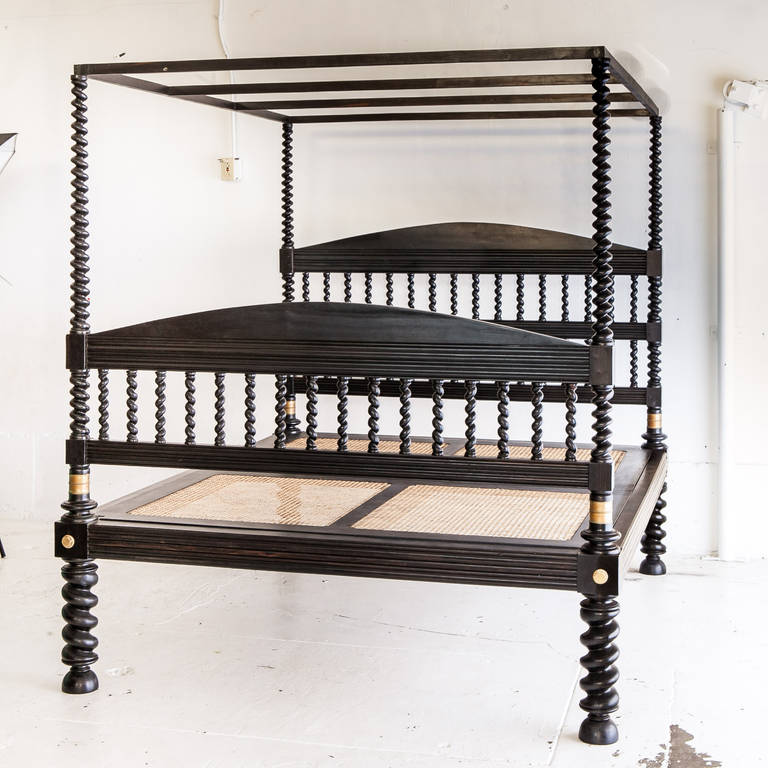 Rare Indo-Portuguese ebony bed with spiral turned posts, legs and head boards. Carving in the all of the side railing and foot board railing. Mattress platform of wood and new caning. Brass hardware. Canopy top which was typically used to hold soft