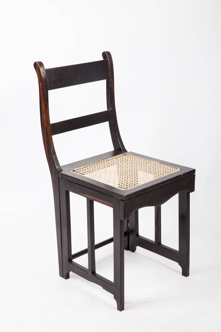 Very unique Anglo-Indian solid ebony Campaign style folding chair. Chair folds flat for ease of transport or storage. Beautiful graining details in the wood. Newly caned seat. We have three pieces in total.