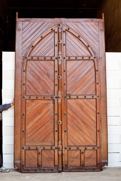 Massive solid teak doors from southern India, left door has small door within door. Doors can be fully functional when mounted with new hardware.