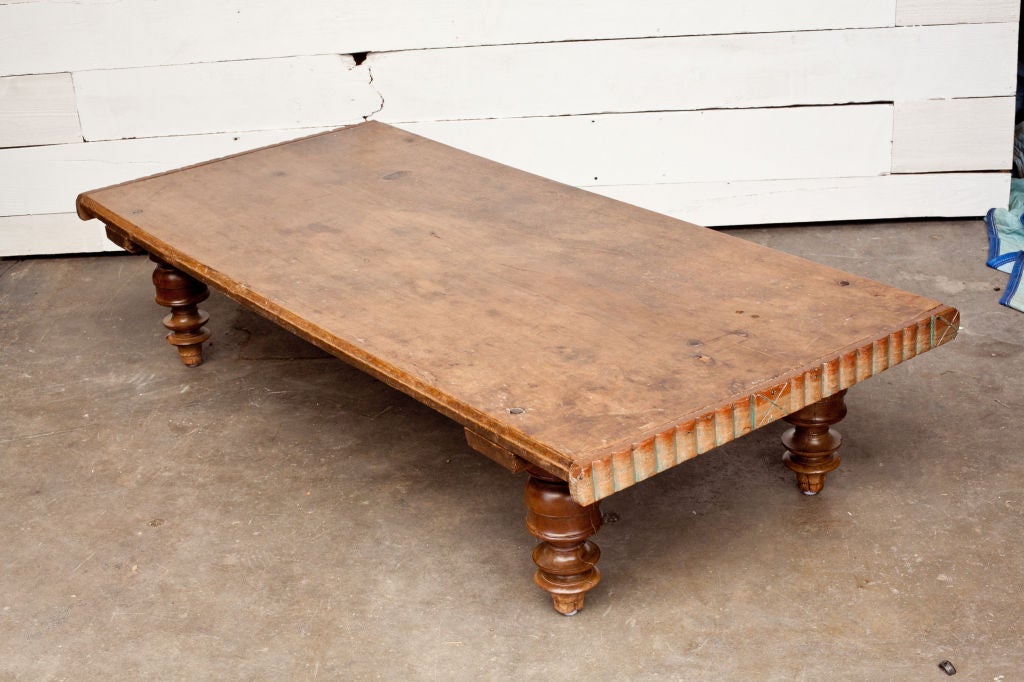 Daybed or low table from southern India made of one enormous plank of jackfruit wood. Top sits on four turned wood legs. Ends of table have scalloped wood applied edge. Makes a great coffee table. Excellent patina.