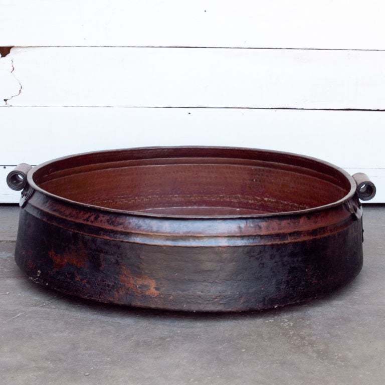 Very large hand-hammered solid copper cooking pot from southern India. These pots were originally used for cooking rice and were placed directly on fires and lifted with poles inserted into side handles. Great floating gardens or fire pits. Several