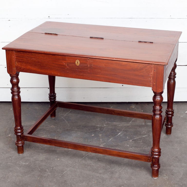 Small sized writing desk from southern India made of solid jackfruit wood. Top is hinged in the center and opens up to reveal several storage compartments.