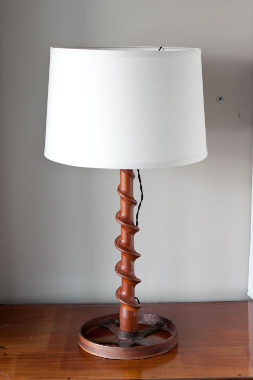 Vintage wood foundry pattern parts that have been constructed into a table lamp. The shade is white linen. The lamp parts are all new. The cord is black cloth covered with an old fashion style plug. The diameter of the wheel base is 10.5