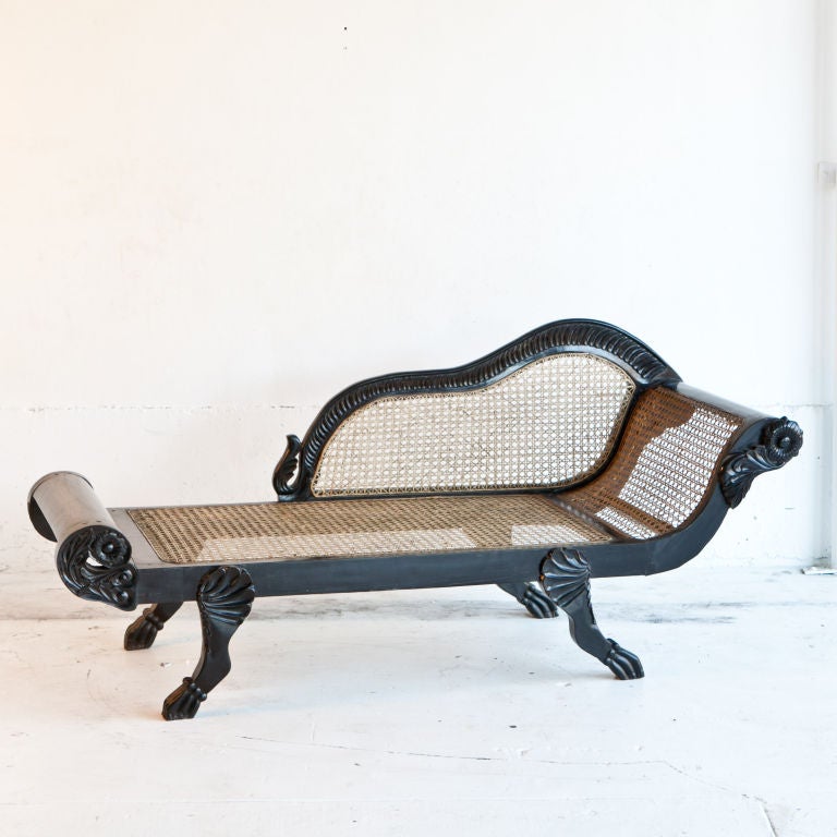 Dutch-Colonial chaise lounge in solid ebony with caned seat and back. Smaller scale lounger with nicely carved details. Seat height = 12