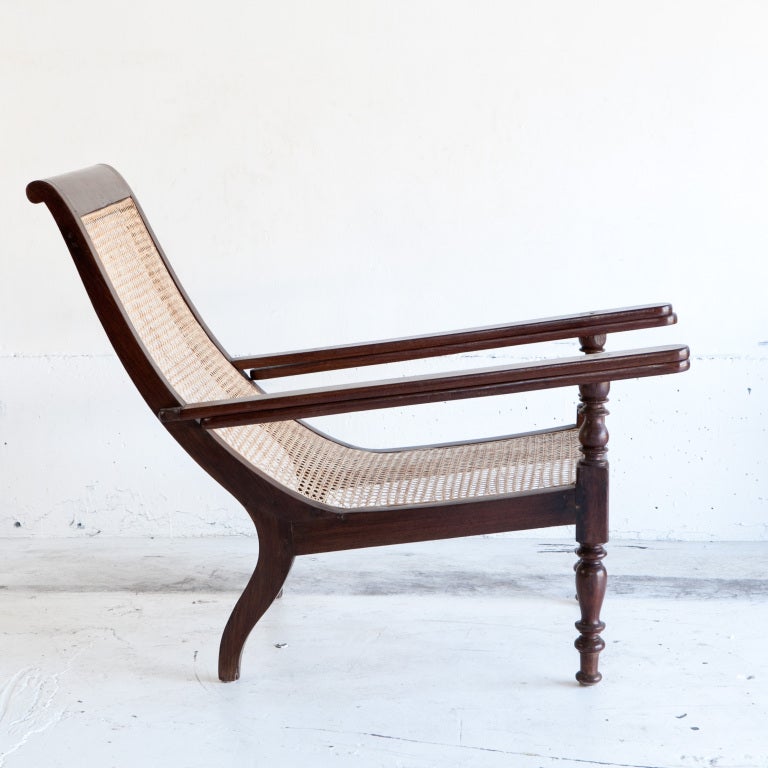 Anglo-Indian rosewood plantation chair with turned wood legs and folding arms. The seat is newly caned.