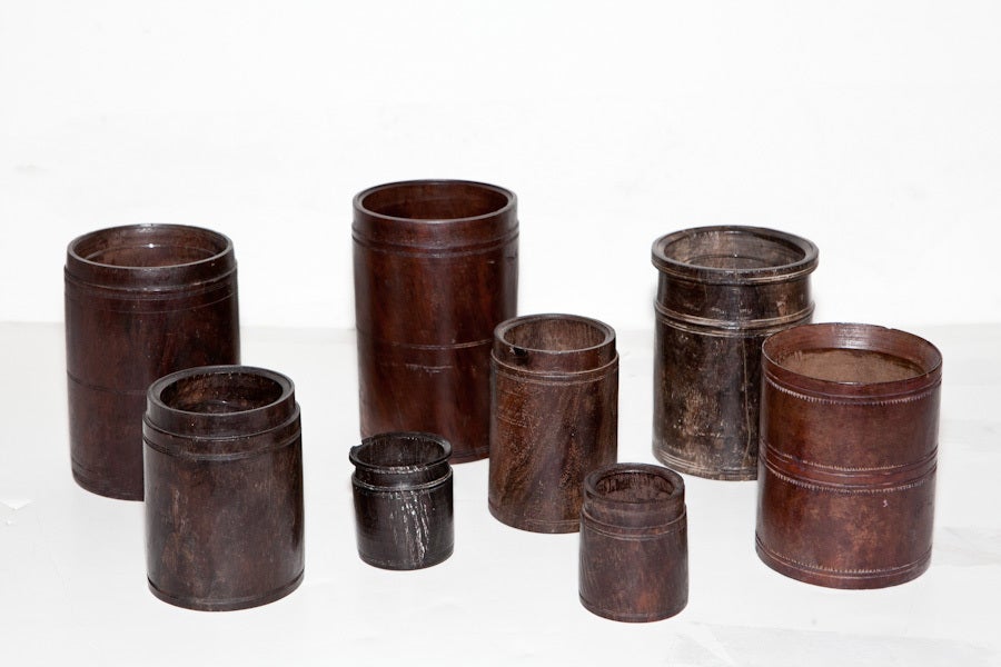 Wood rice measurers from Southern India turned from solid blocks of tropical hardwood like ebony and rosewood. All cups have carved details. Several cups have glass inserts and can be used as vases.