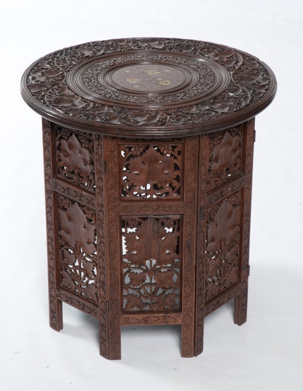 Anglo-Indian rosewood teapoy with elaborately carved base and top and brass inlay. Top and bottom separate and bottom folds flat. 