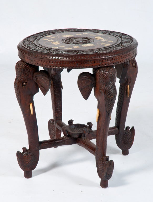 Anglo-Indian carved rosewood table with stylized elephant heads for the base including bone tusks. The top is inlaid with a leaf pattern from ivory. 
