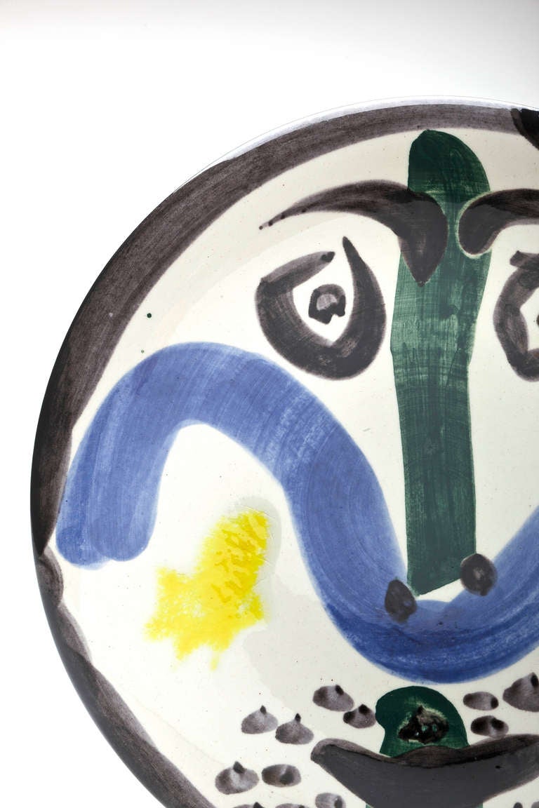 A plate that makes you smile by Picasso (1881-1973).  Glazed earthenware with engobe decoration and enamel.   Signed 