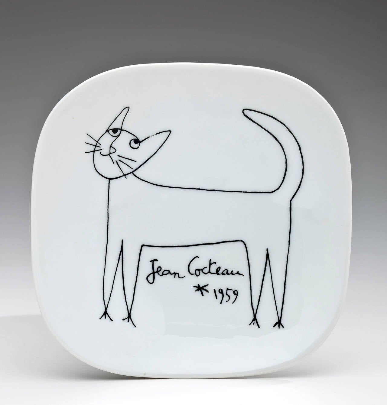 A white glazed ceramic plate with the drawing of a cat by Surrealist artist Jean Cocteau. The plate, designed by Cocteau, was produced by Limoges Signed and dated by Cocteau, as well as Limoges.
