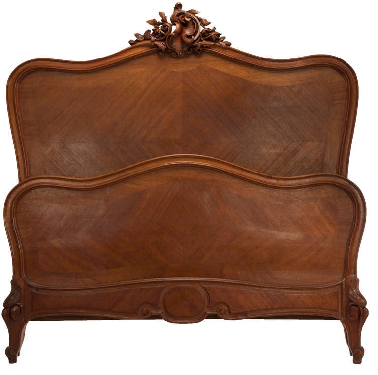 Double size Louis XV style carved French walnut bed, bookmatched veneer panels on head board and foot board, nicely carved cabriole legs with shells, paneled side rails and foot rail, finely carved crest on head board. A finely made reproduction
