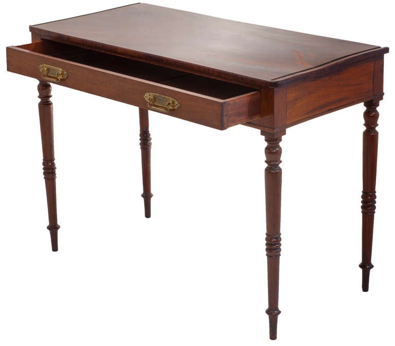 Regency table desk, mahogany with banded veneer, tapered turned legs, full width dovetailed drawer in apron with finely chased brass pulls.