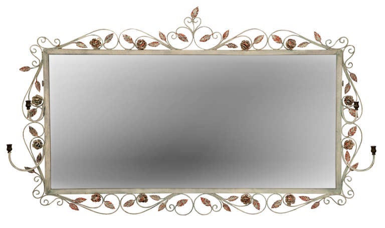 Landscape mirror with wrought iron frame of scroll work, leaves and roses with two attached candle arms, painted in French white and pink.