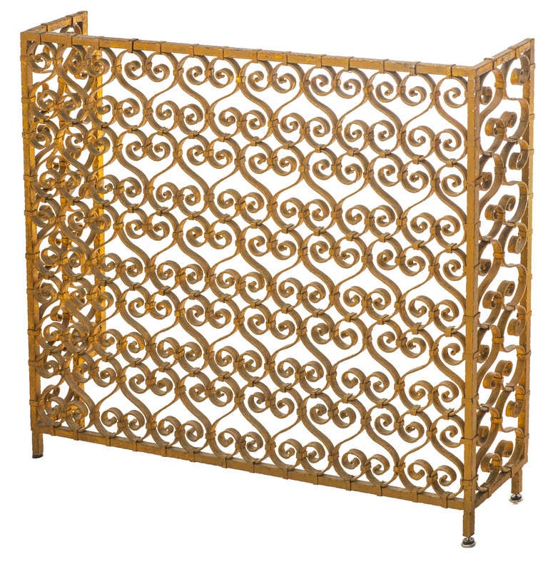 Scrolled iron works covered in gilt on fireplace screen. This piece has been custom cut on one side. So the sides are not symmetrical, see image 4.