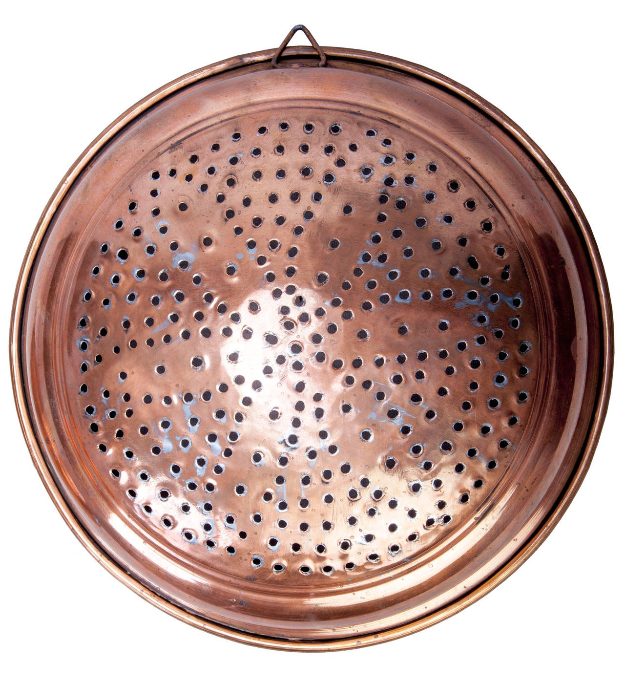 Two copper strainers, large is 12 inch diameter, tin lined with a triangular hanging loop and the holes are arranged in a petaled flower pattern.
Small is 9 inches in diameter, solid copper with no lining with circular hanging loop, with holes