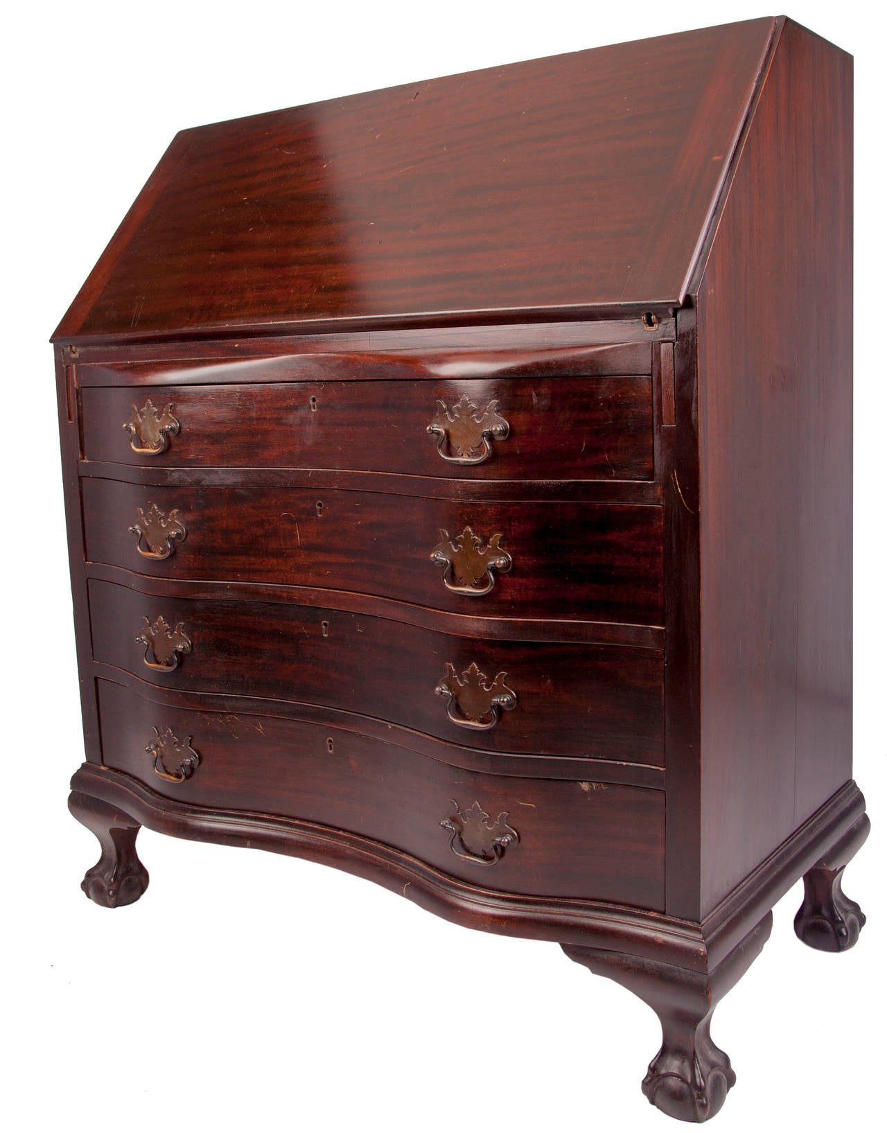 Fine serpentine shaped front on this reproduction mahogany secretary from the turn of the 20th century, four nicely shaped drawers with Chippendale Style brass pulls and key escutcheons , fall front desk with support arms extending outward