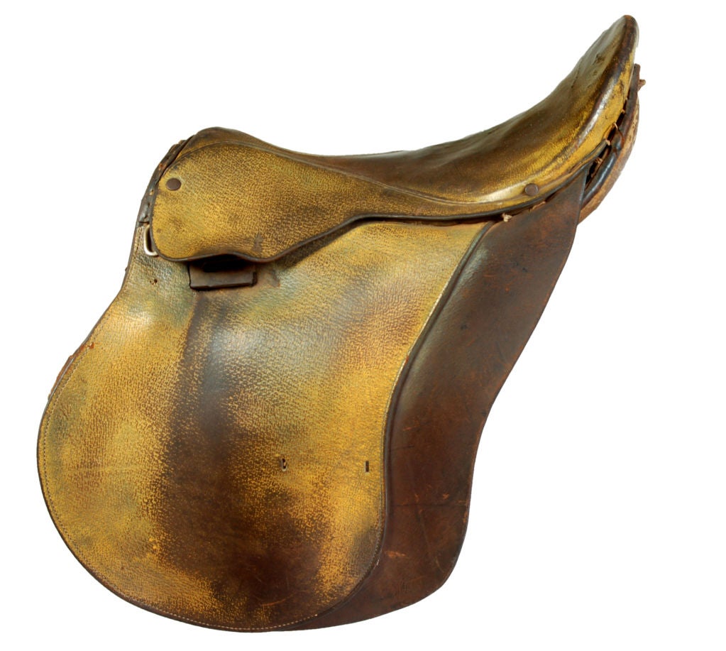 This classic English riding saddle has a rich velvety texture. Weathered by age and wear, the dark rich muted tones are set off by the sun kissed golden spots. Hand stitching can been seen throughout. A wonderful show piece.