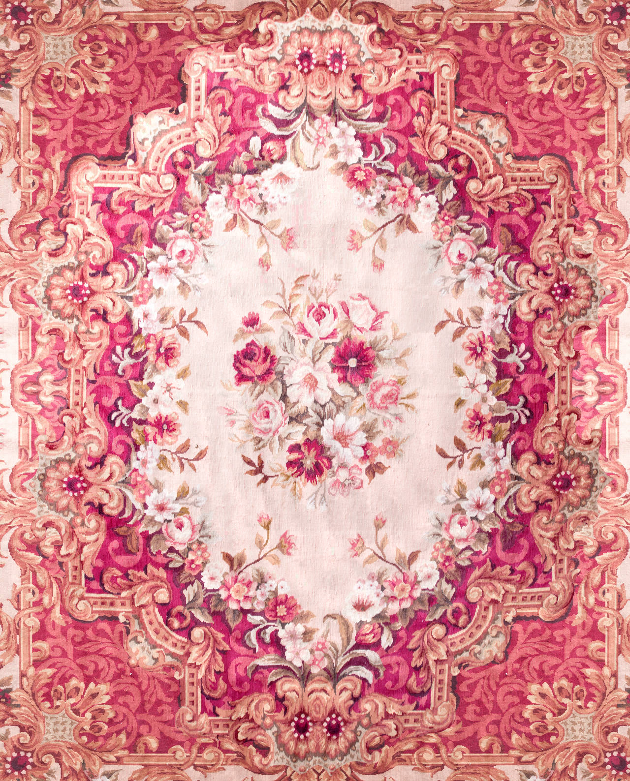 Room sized hand-stitched needlepoint rug in a flamboyant Rococo style with floral bouquets, arabesques, shells and ribbons, beautiful floral bouquet in the ivory ground center medallion. Mixed pallet of watermelon pink, fuchsia and creamy peach.