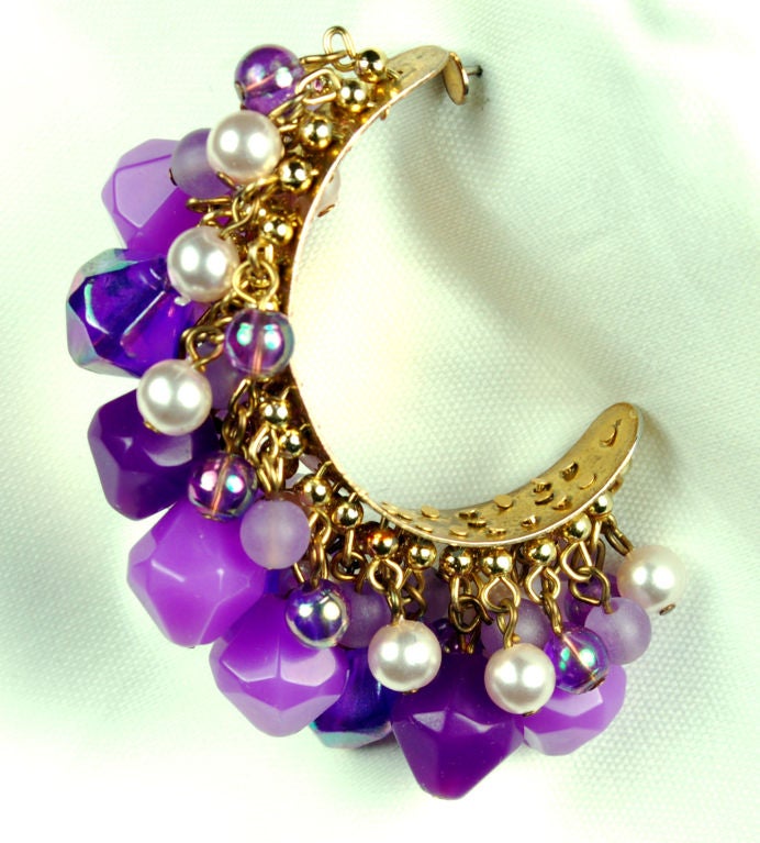 These wonderful purple and pearl hoop earrings are exploding with character and charm. Beads of multiple shades of purple are suspended from hooks causing the individual beads to move separately. The earrings themselves are generously laden with