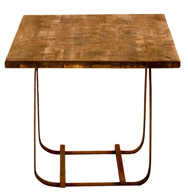 Table unique avec plateau rectangulaire en bois robuste et base en fer forgé.