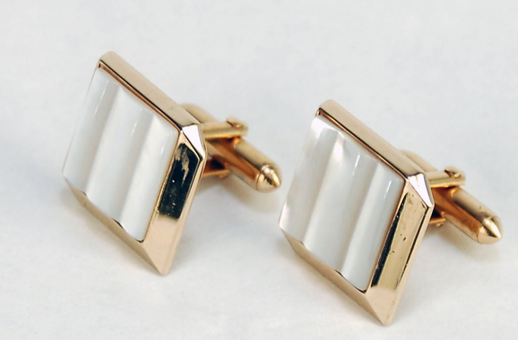 This swinging pair of Swank mother of pearl and gold geometric cuff links feature a masculine, thick, clean and modern design. The mother of pearl face, created using a technique that allows the piece to become raised, giving the illusion of ocean
