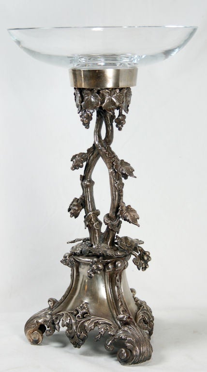 This pair of ornate silver torchieres were produced by Indian craftsmen. They sit on three scrolled feet and laden with grape vines climbing up the body. These pieces were cast of white bronze and plated with silver. Removable fine crystal glass