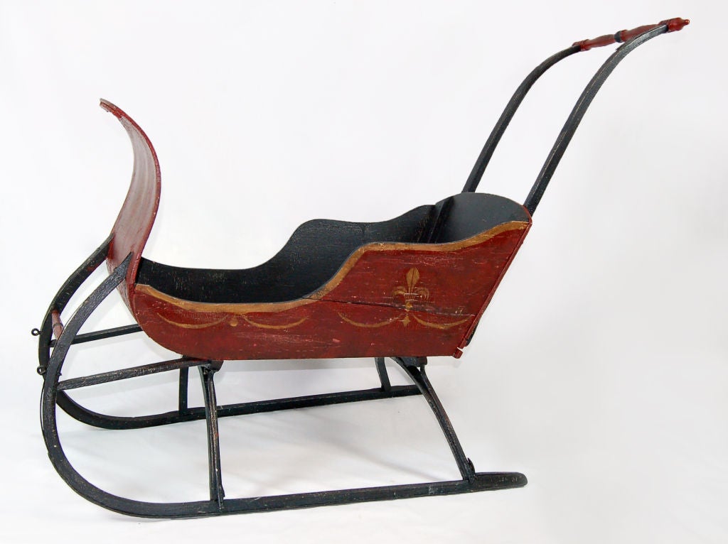 This whimsical piece was hand made out of old soda cartons and other scrap woods. The evidence of this the unpainted bottom of the piece displays an old squirt ad. The whole sits on curved iron rails and features a push bar so that this sleigh can