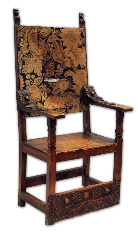 This pair of majestic armchairs features two carved lion head finials with ornately carved arms and foot-rails, plank seats and a tapestry upholstered back. These are two beautiful examples of Spanish Colonial style, considered to come from the 1600