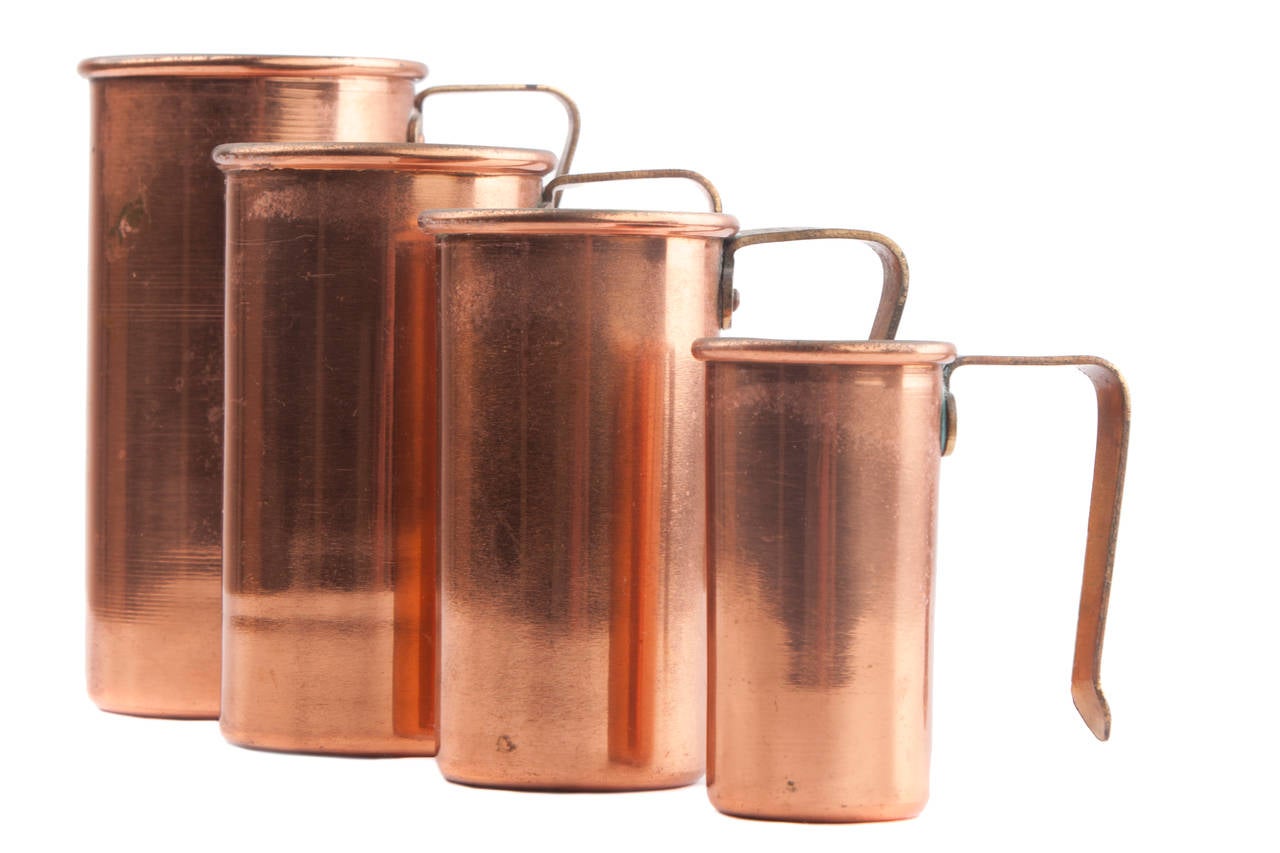 Benjamin & Medwin Inc. copper measuring cups, circa 1970s.
This is a set of four solid copper measuring cups and they also come with a brass rack. Made in Korea by Benjamin Medwin, Inc., they are in very nice vintage condition and there is a little