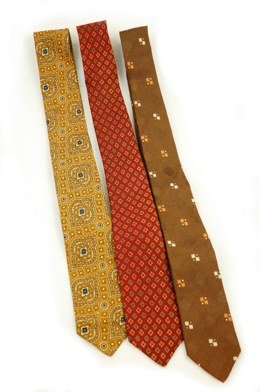 This collection of mid century skinny ties are fit to be tied. The first necktie is done in a paisley print in yellow ocher and sea blue it was made in Italy and composed of 100% silk and sold by Zachry of Atlanta in the early 1950's. The second