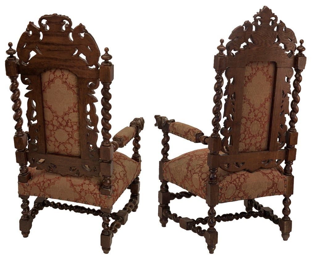Museum quality Italian renaissance revival pair of carved walnut padded armchairs with barley twist dog-like arm cups have crests adorned with griffons and cartouche. Beautiful red and gold brocade in excellent condition with nailhead trim. Each