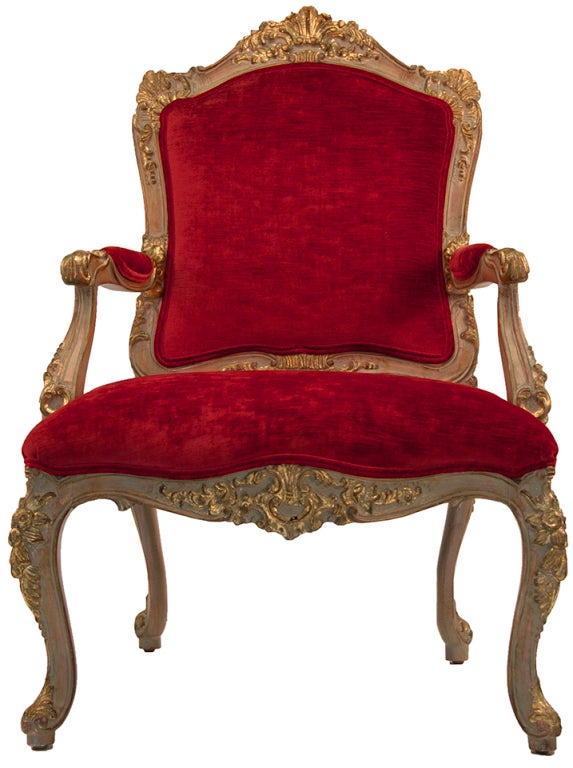 Pair Of Louis XV Style open arm salon chairs, opulently carved, painting and gilded wood frames merlot colored silk velvet upholstery, self welt trim, one frame has carved gilded bows and swags applied to the outside back, contrast outside backs in