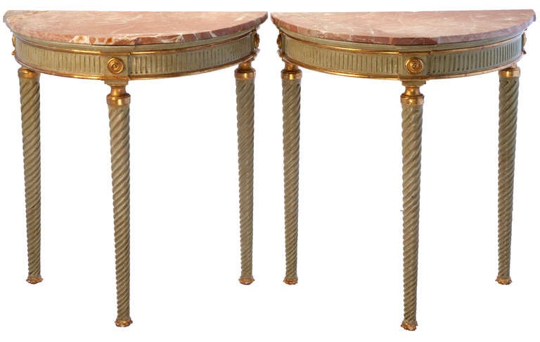 Painted green with gold leaf and trimmed feet, these demi lunes have been restored with custom rose marble tops.
