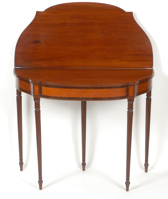 An excellent Federal mahogany and inlaid five-leg games table Boston, Massachusetts, circa 1810. This nicely proportioned games table has a wonderful old surface with a mellow patina.  The shaped top has serpentine sides and a bowed front.  The