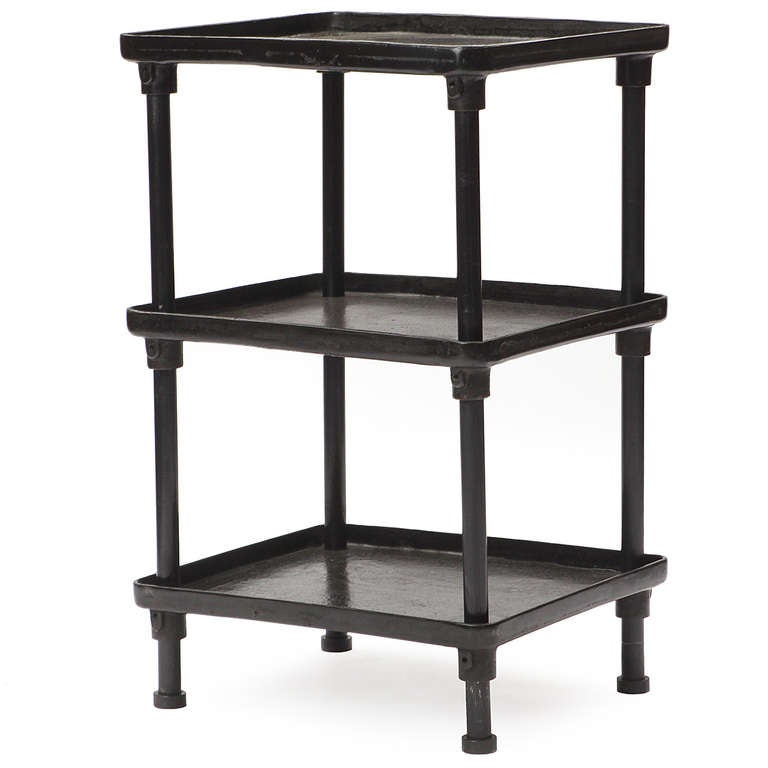 A tall, heavy and well-crafted three-tiered industrial table rendered in richly patinated steel and iron, having adjustable shelves with raised edges.