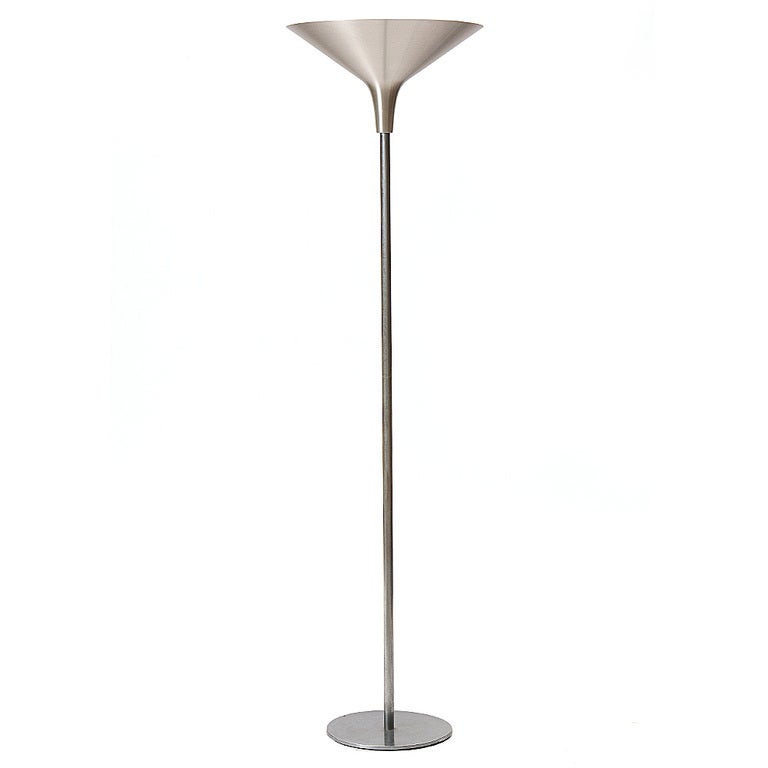 A vintage brushed aluminum torchiere lamp with a wide shade and single bulb.