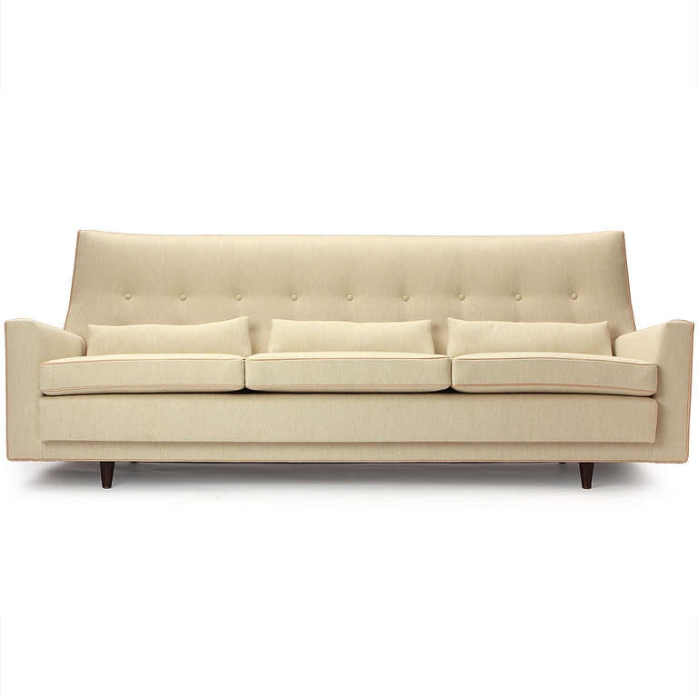 An elegant, clean-lined and finely proportioned high-back sofa beautifully upholstered in a cream Savak wool with natural leather welting.