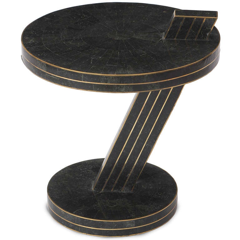 A dramatic occasional table in tessellated emerald marble with fine brass detail having an angled cantilevered top rising from a disc base.