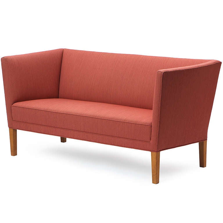 An early Grete Jalk designed settee featuring a high back on squared legs with a tight and tailored pale brick upholstery. Crafted by Johannes Hansen in Denmark, circa 1950s.

Working at a time when women were a rarity in the design world, Grete