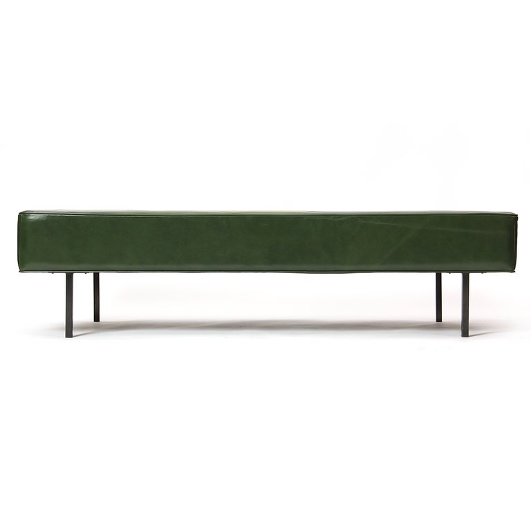 A large daybed or bench on four square black steel legs in the original green leather upholstery. Made by H G Knoll