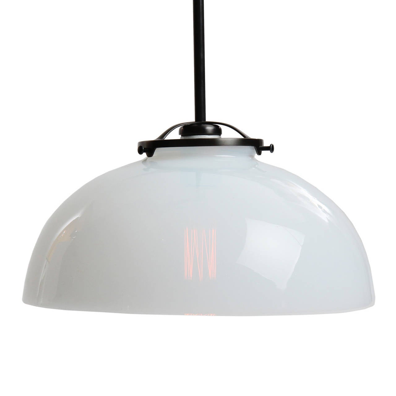 Un lampadario semplice con un paralume emisferico in vetro lattiginoso realizzato in modo impeccabile e collegato a un'asta in acciaio nichelato e a una piastra di montaggio.