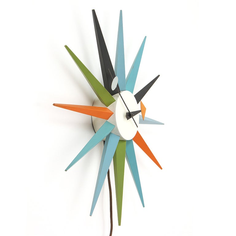 An electrical wall clock made of painted aluminum and natural solid oak wood. Manufactured by Herman Miller.