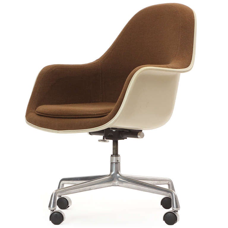 A fully adjustable upholstered desk chair having a molded fiberglass body resting on an early four-pronged aluminum base with casters.